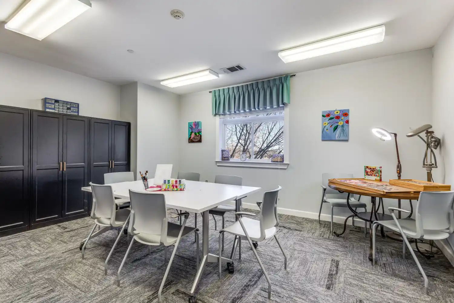 Senior living community activity room with art table and seating at The Ivy of McKinney assisted living Texas