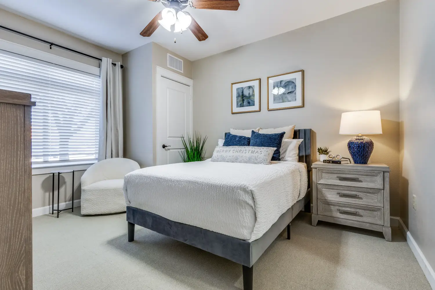 Senior living apartment bedroom with bed nightstand and window at The Ivy of McKinney assisted living community Texas