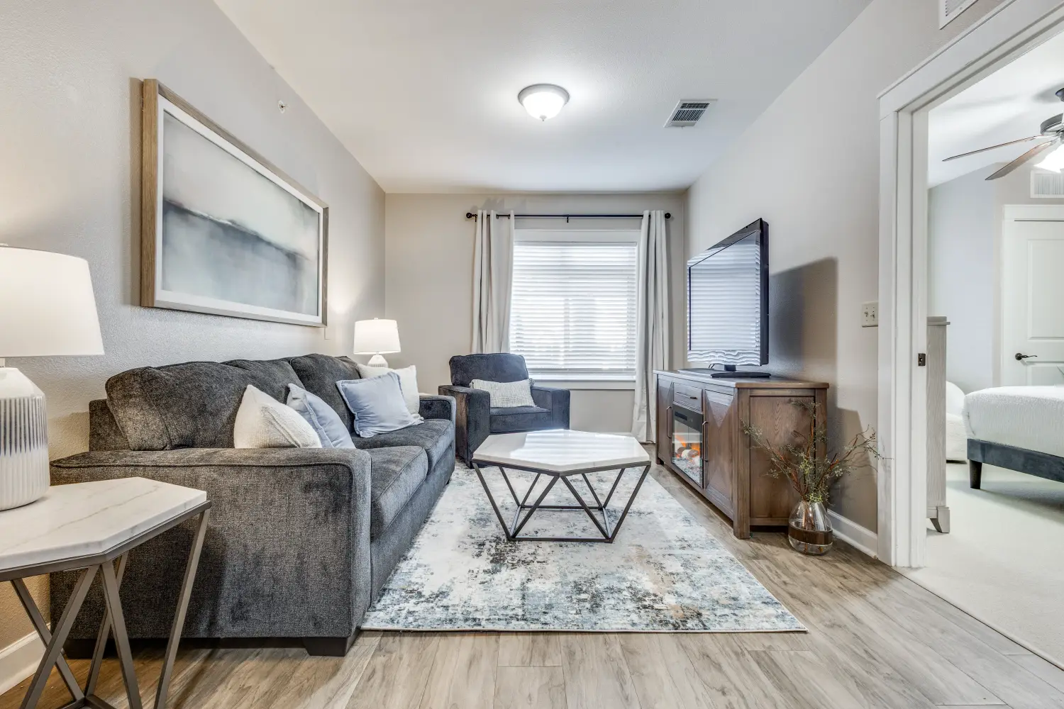 Senior living apartment living room with sofa seating and television at The Ivy of McKinney assisted living Texas